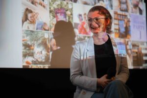 Bookfluencerin Theresa Haubs im Gespräch mit Laura Klingelhöfer von Adel und Link. Im Hintergrund ist ihre Präsentation zu sehen mit einer Übersicht ihrer Book Talks auf Instagram.