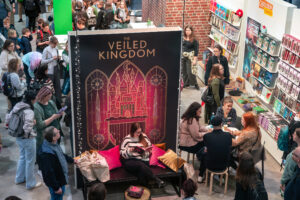New Adult Messestad auf der Leipziger Buchmesse 2025 umringt von zahlreichen Menschen.